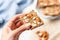 hand with napkin holding an almond butter toast slice