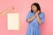 Hand Offering Shopping Bag To Shopaholic Girl Over Pink Background