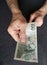 hand of an older man holding a czech banknote of 100 korun