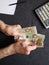 hand of an older man holding a peruvian banknote