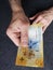 hand of an older man holding a swiss banknote of ten francs