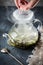 Hand open lid of kettle with herbal tea from peppermint boiled h