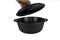 The hand opens the lid. Cast iron pan,  cast iron pot, empty, black. From the side