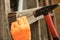 Hand in orange gloves hammer a nail