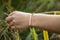 hand outdoor touching plants with pearl and hematite bracelet