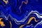 Hand painted background with mixed liquid blue and golden paints. Abstract fluid acrylic painting. Modern art. Marbled