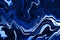 Hand painted background with mixed liquid blue paints. Abstract fluid acrylic painting. Modern art. Marbled blue