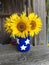 A hand painted mason jar filled with fresh sunflowers