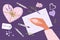 Hand with pen is going to write. Letter pattern, pens, confetti, stickers, heart-shaped gift box, lavander plant on