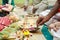 a hand performing hindu ritual pooja yajna indoor with flowers and brass utensil