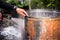 The hand of the person holding the water hose to clean dirt and stains on the washing tank.