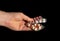 Hand persons holding pills in hand  on black background