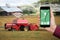 Hand with phone. On the screen control interface of the self driving combine harvester.