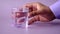 hand pick a glass of water on purple background