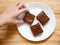 Hand picking homemade chocolate brownies