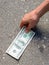 Hand picking money from street floor - Finding money on street concept