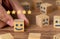 Hand picking smiling faced wooden cube and 5 stars.