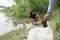 Hand picking up paper cup cleaning on the river beach. Volunteer cleaning up the garbage. Stop plastic. Recycling