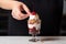 hand placing a cherry on top of a sundae