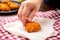 hand placing a chicken nugget on a napkin