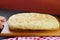 Hand Placing a Freshly Baked Herbed Focaccia Bread on the Table