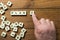 Hand placing the letter Z next to the word PLAN on a wooden background