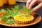 hand placing mint leaf on top of a citrus fruit tart