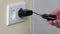 Hand plug charger adapter into wall socket.