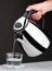 Hand pouring chrome kettle water boiler isolated