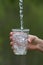 Hand pouring clean natural water into a glass