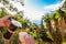 Hand Pouring Coffee In Cup against ocean, blue sky and exotic trees