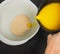 Hand pouring melted butter into a white bowl with dry yeast