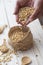 Hand pouring soybean seeds in basket and in wooden spoons - kedelai