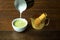Hand pouring steam milk on hot matcha green tea latte