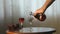 Hand pours a liqueur in wine glasses from a carafe