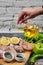 Hand pours oil to plate of raw chicken meats with bunch of vegetables