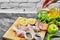 Hand pours oil to plate of raw chicken meats with bunch of vegetables