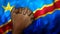 A hand praying with Flag of Democratic Republic of the Congo as background. Grunge, depressing look.