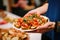 hand presenting a plate of garlic bruschetta to audience