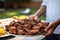 hand presenting a platter of honey bbq wings at a gathering