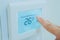 Hand press the touch screen panel of air conditioner to increase the temperature. Energy saving concept