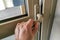 A hand pressing a door handle to open or to close the door
