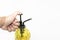 Hand pressuring yellow spray glass bottle isolate