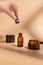 Hand, product and serum with a woman on a beige background to promote an antiaging treatment. Skincare, beauty and