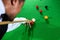 Hand of professional snooker player closeup aiming shot white ball