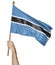 Hand proudly waving the national flag of Botswana