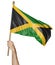 Hand proudly waving the national flag of Jamaica