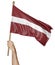 Hand proudly waving the national flag of Latvia