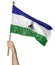 Hand proudly waving the national flag of Lesotho