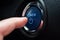 Hand push on car engine power start button closeup